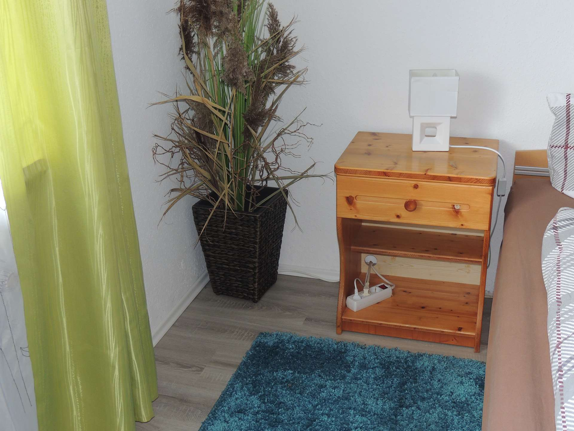 Nachttisch mit weißer Lampe und Schublade, Kunstpflanze im hölzernen Blumentopf